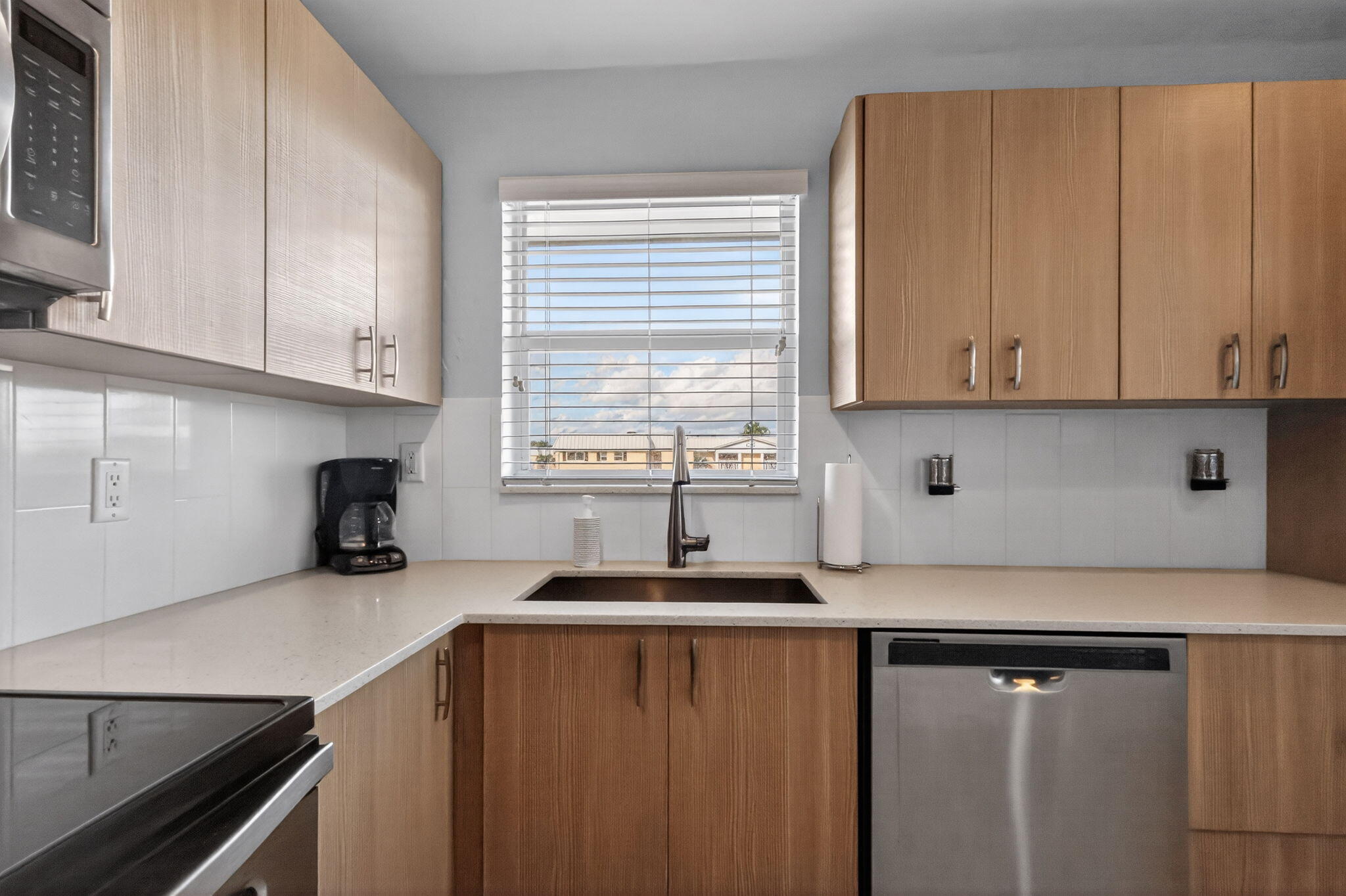 12 Colonial Club Drive, Unit 305 Boynton Beach, FL 33435 - Photo 28 of 51 a kitchen with granite countertop a sink cabinets and window
