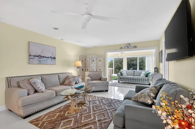 a view of a dining room and livingroom with furniture wooden floor a chandelier