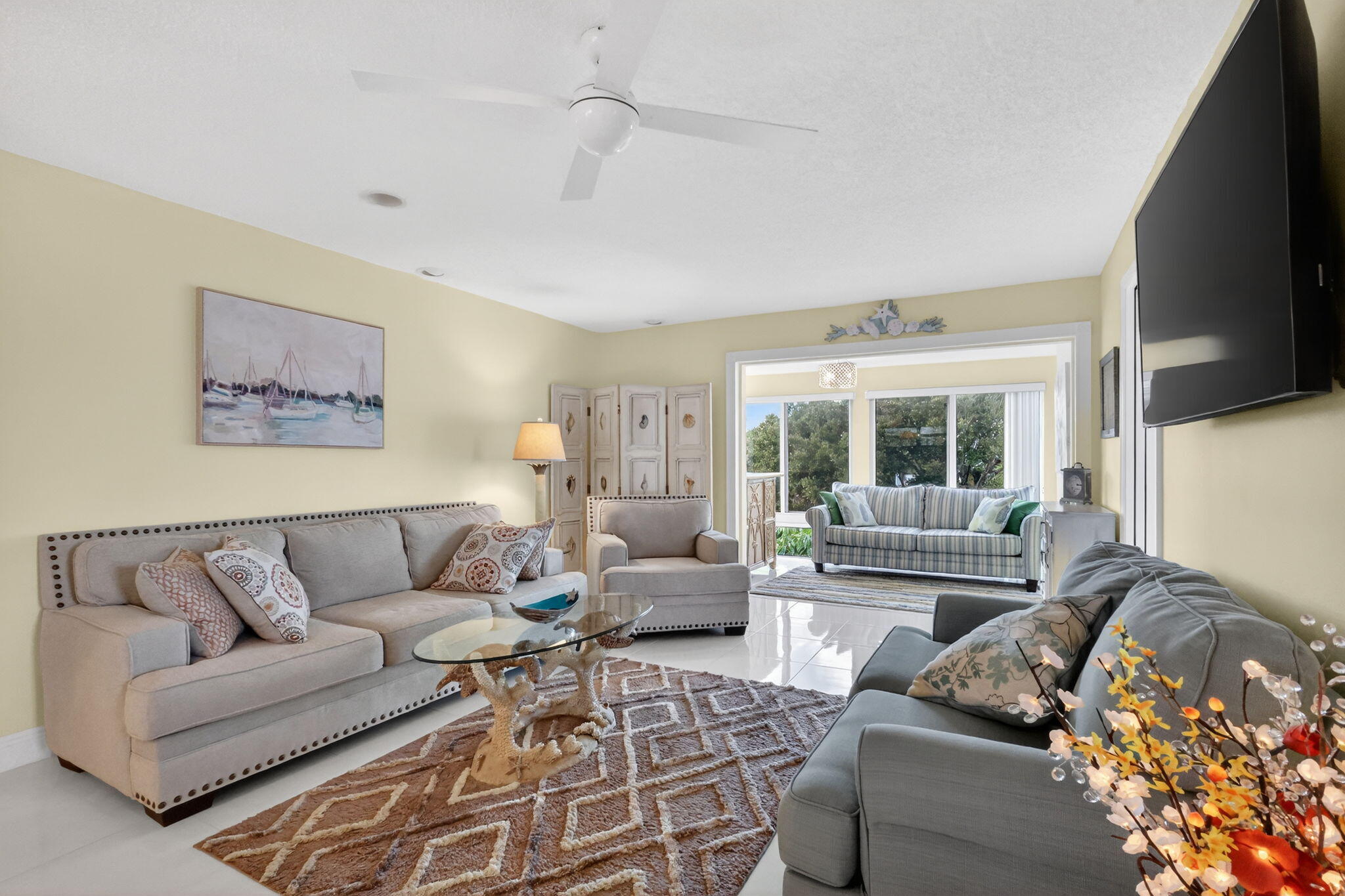 12 Colonial Club Drive, Unit 305 Boynton Beach, FL 33435 - Photo 6 of 51 a living room with furniture a large window and a flat screen tv