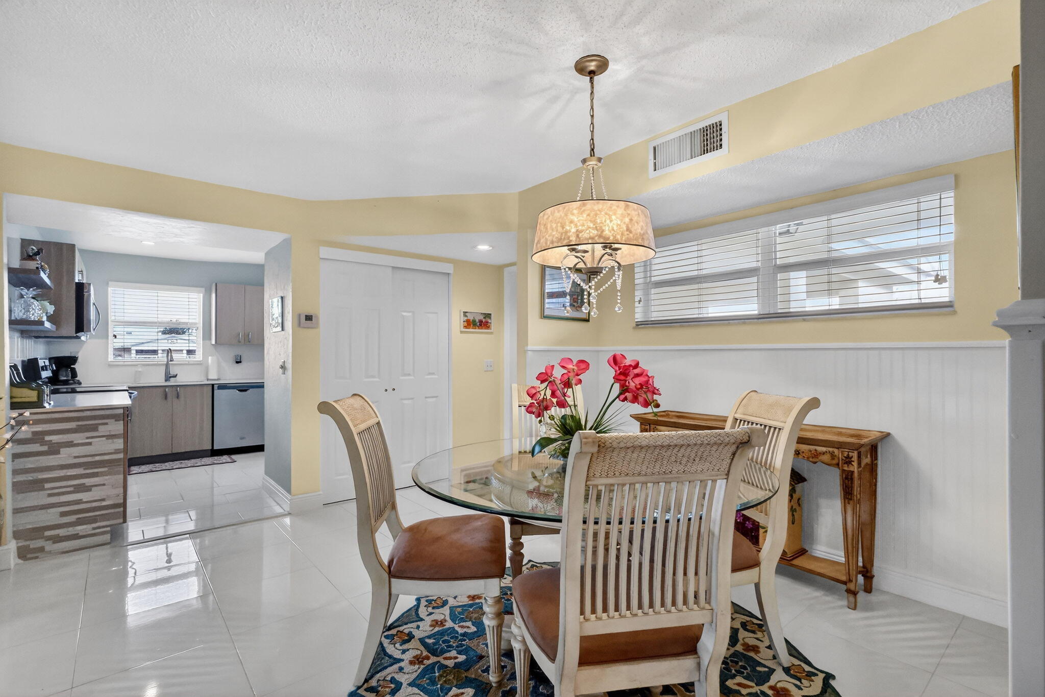 12 Colonial Club Drive, Unit 305 Boynton Beach, FL 33435 - Photo 7 of 51 a view of a dining room and livingroom with furniture wooden floor a chandelier