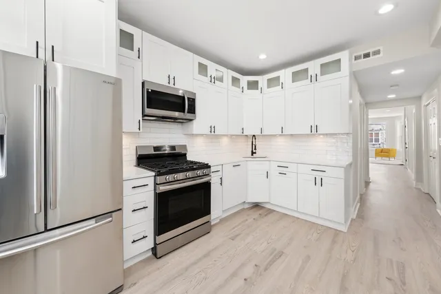 a view of a kitchen with sink and dishwasher with wooden floor