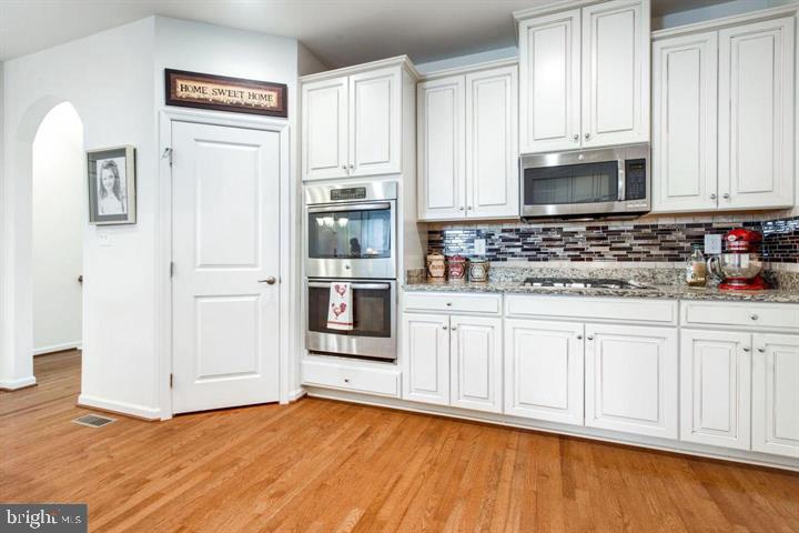 41663 McMonagle Square Aldie, VA 20105 - Photo 5 of 22 a kitchen with stainless steel appliances granite countertop a refrigerator sink and white cabinets
