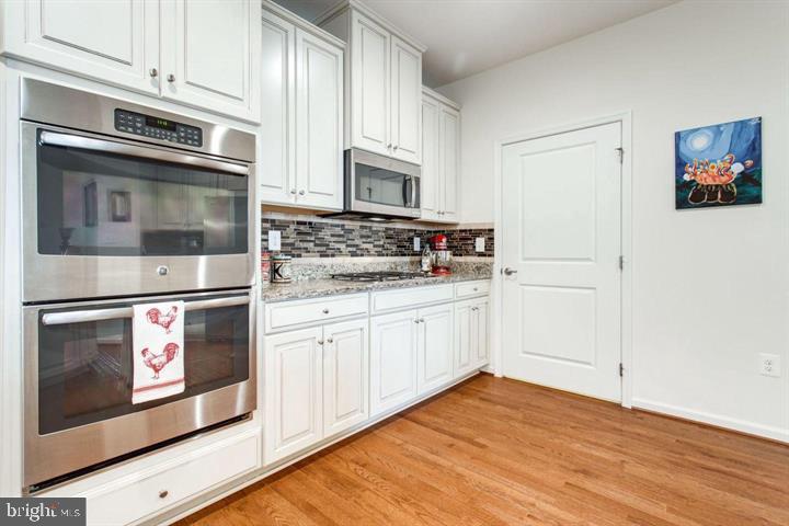 41663 McMonagle Square Aldie, VA 20105 - Photo 9 of 22 a kitchen with stainless steel appliances granite countertop a stove microwave and oven