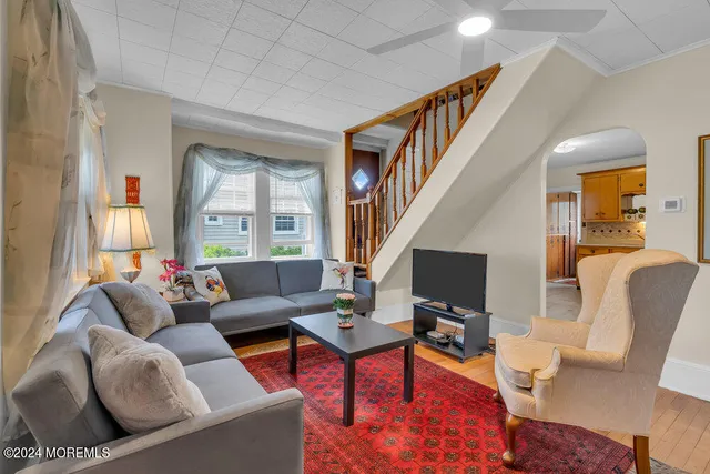 a living room with furniture flat screen tv and a window