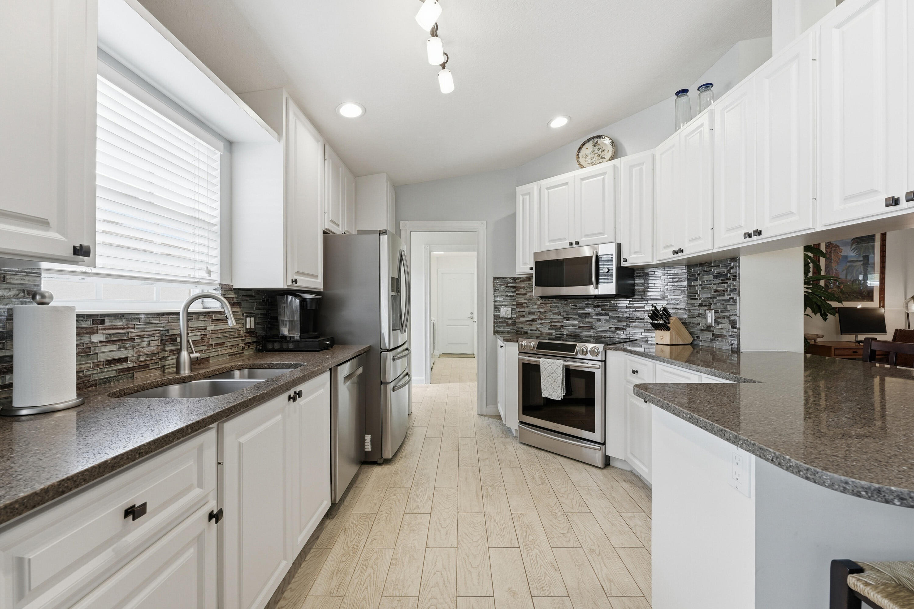 1019 Southwest Tamarrow Place Stuart, FL 34997 - Photo 8 of 34 Kitchen with tile backsplash and granite