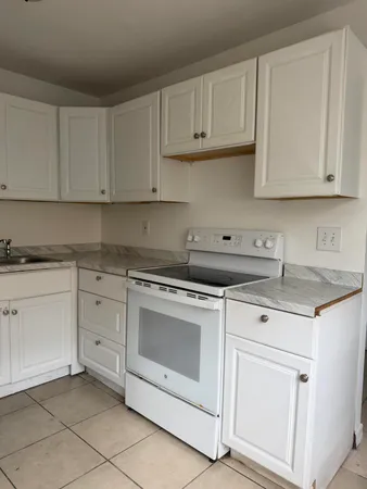 a kitchen with white cabinets and white appliances