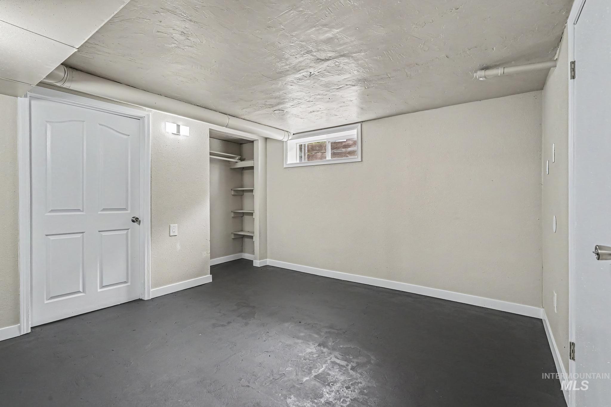1023 State Street Weiser, ID 83672 - Photo 15 of 25 Finished room featuring painted concrete flooring, an egress window, and a built-in closet with shelving and hanging rod