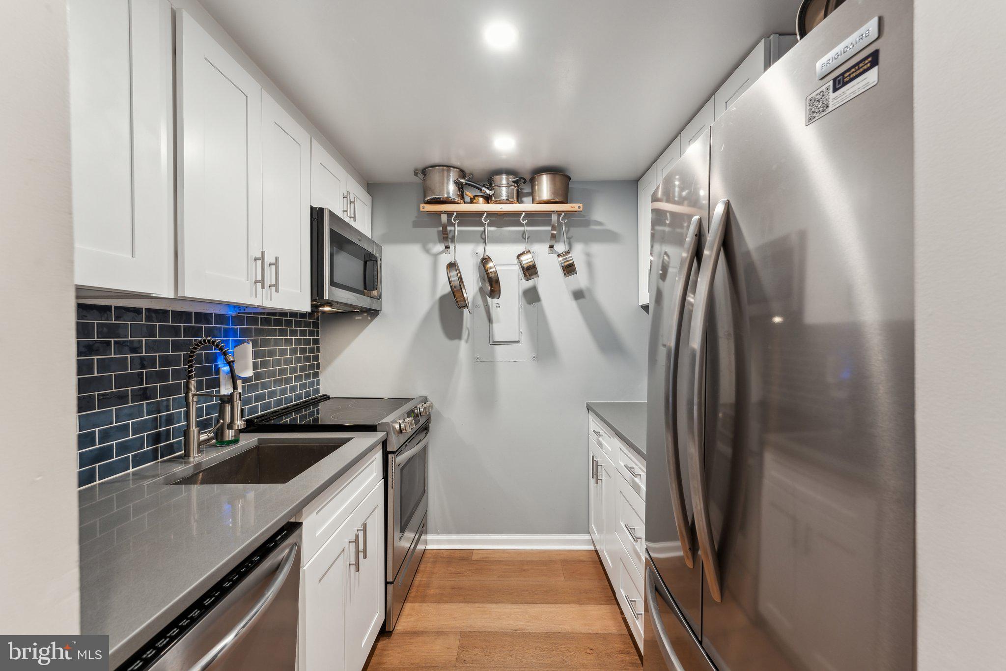 1844 Columbia Road Northwest, Unit 103 Washington, DC 20009 - Photo 17 of 21 a kitchen with stainless steel appliances granite countertop a refrigerator and a sink