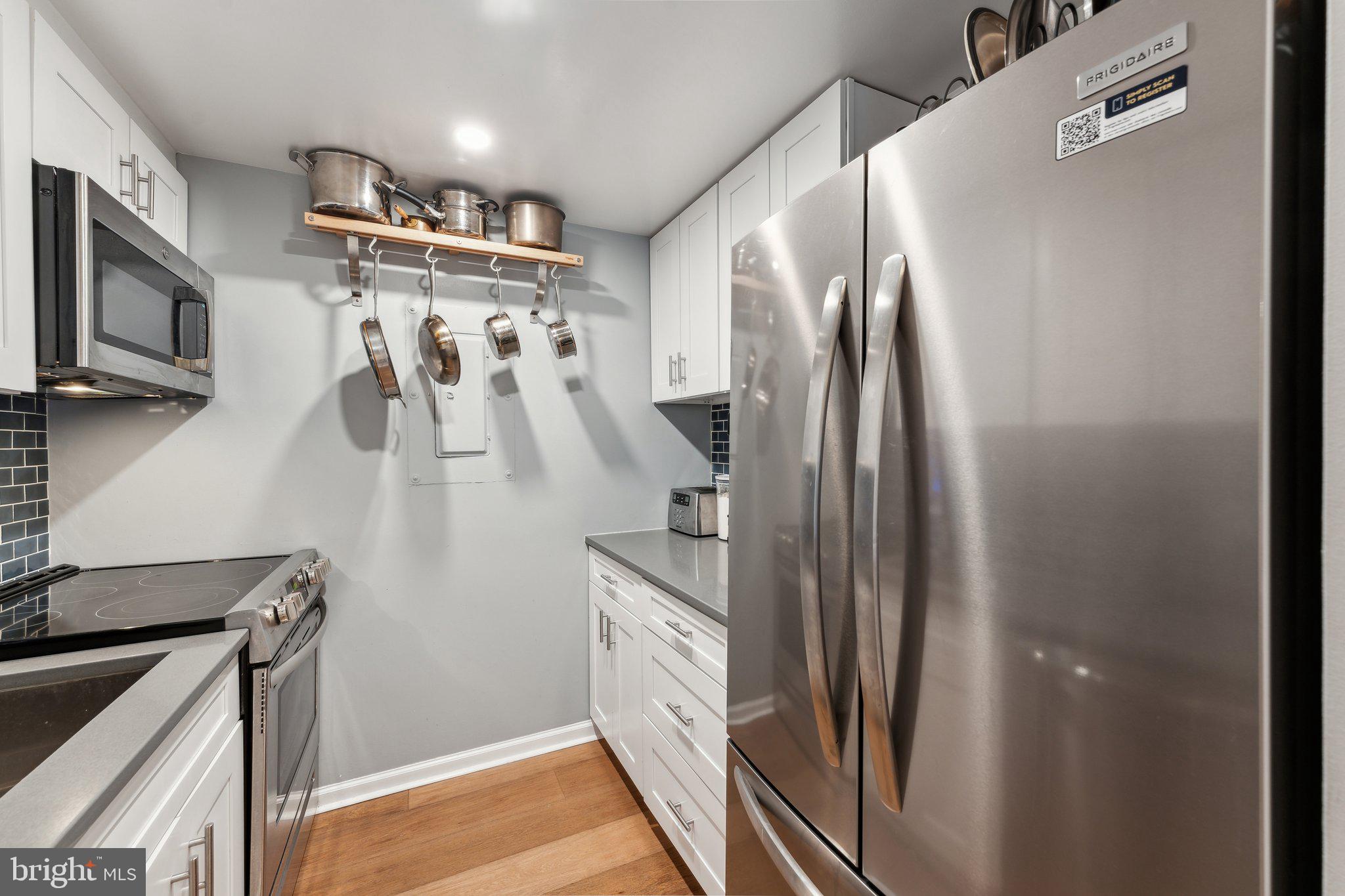 1844 Columbia Road Northwest, Unit 103 Washington, DC 20009 - Photo 18 of 21 a kitchen with stainless steel appliances granite countertop a refrigerator and a stove