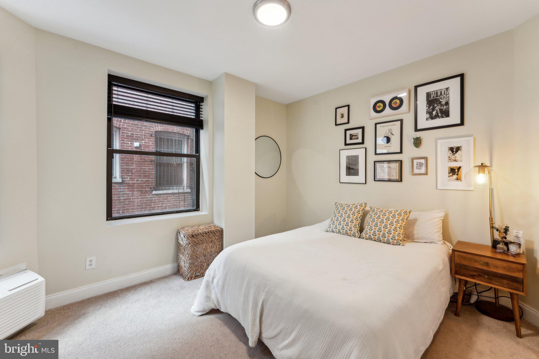 1844 Columbia Road Northwest, Unit 103 Washington, DC 20009 - Photo 2 of 21 a bedroom with a bed and a lamp