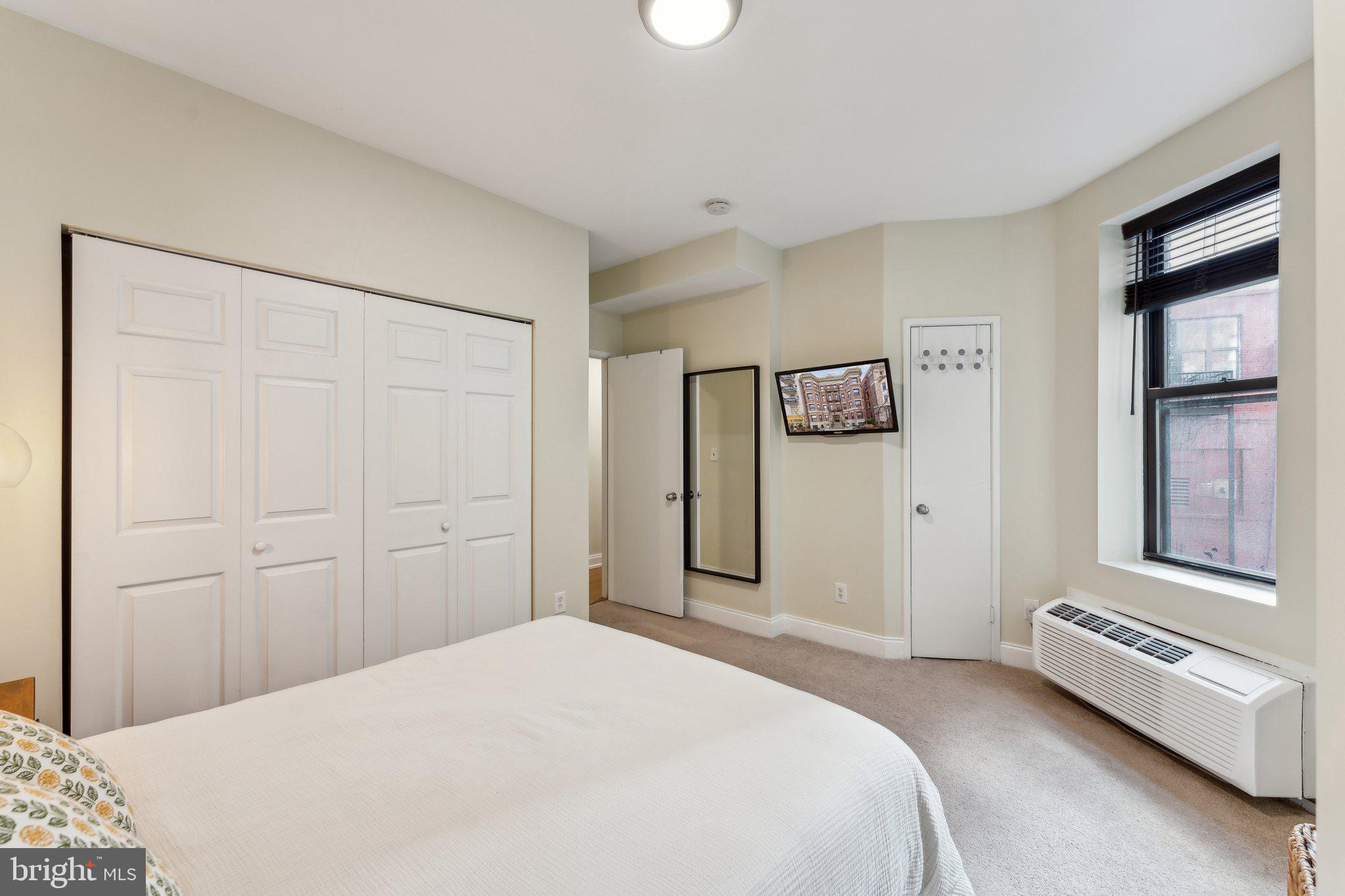 1844 Columbia Road Northwest, Unit 103 Washington, DC 20009 - Photo 3 of 21 a bedroom with a bed and a window