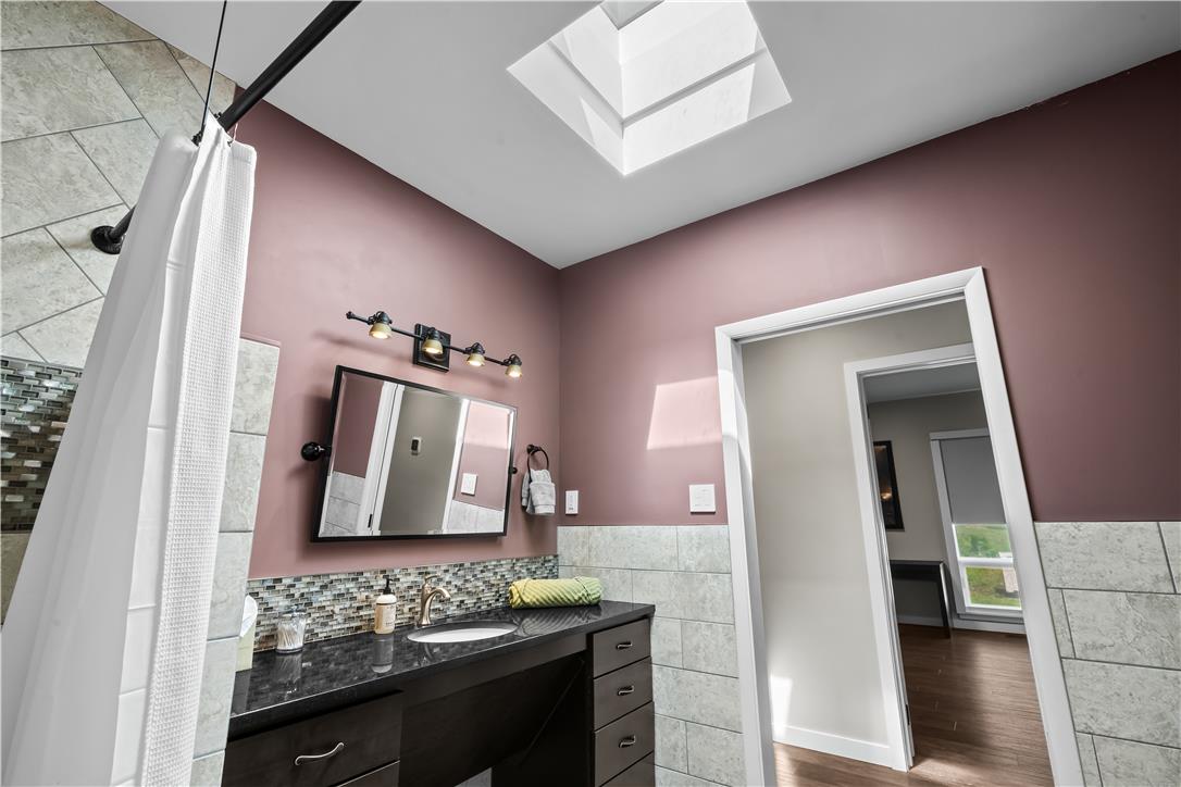 1506 Pleasant View Road Coopersburg, PA 18036 - Photo 60 of 97 Natural light floods this bath through a skylight, highlighting the sleek vanity and modern fixtures.