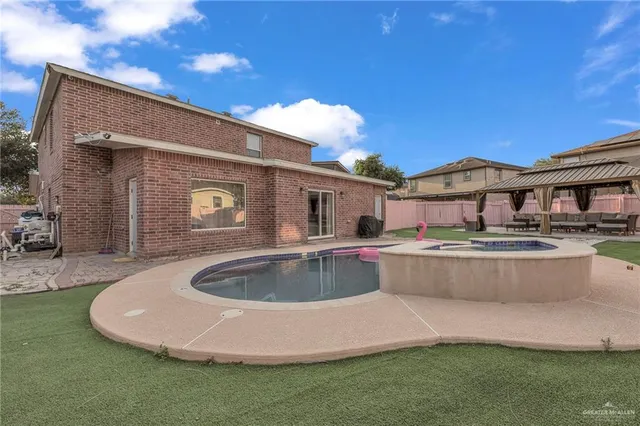 a view of a house with pool and a yard
