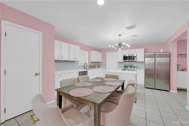 a kitchen with kitchen island a appliances dining table and chairs