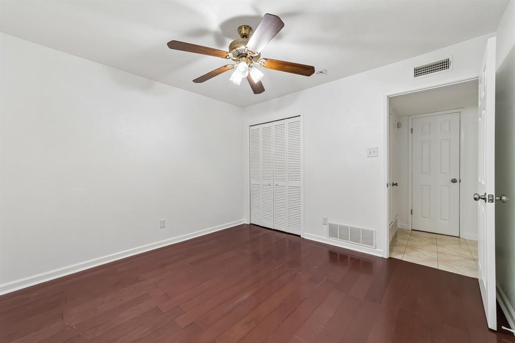 10239 Green Ash Road Dallas, TX 75243 - Photo 26 of 36 Interior room featuring rich wood-finish flooring, white walls, and a ceiling fan with light fixture