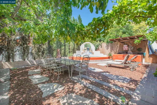 a view of a patio with chairs and a large tree