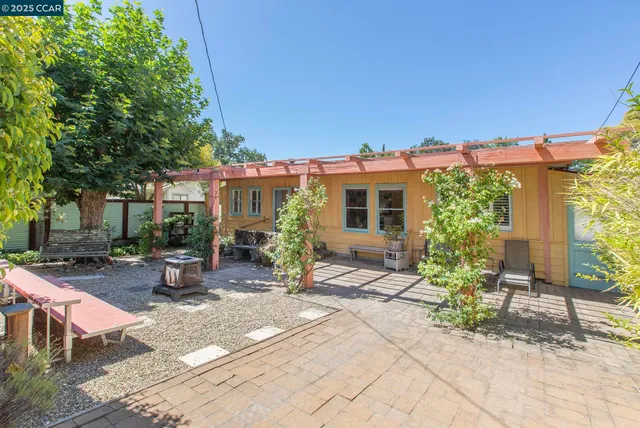 a view of a patio with table and chairs under an umbrella