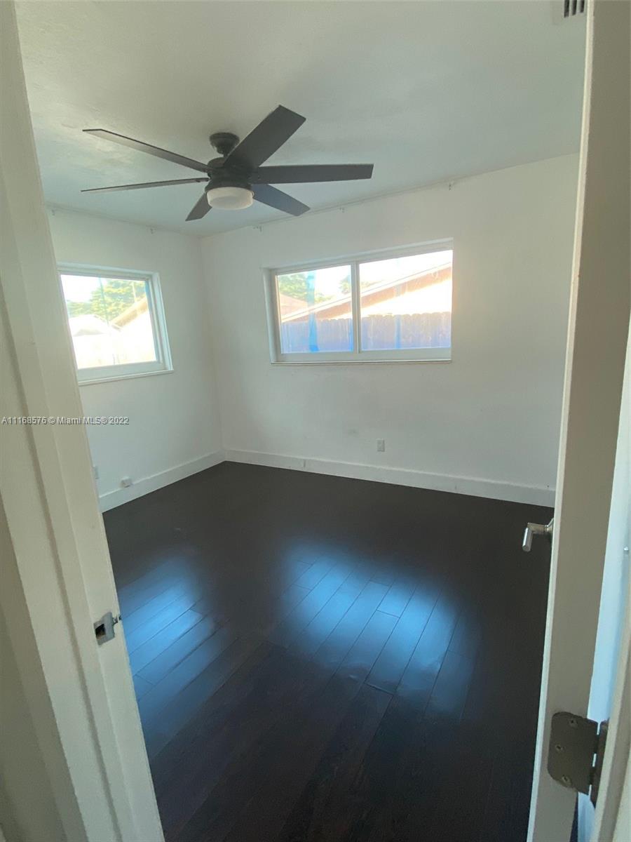 6561 Southwest 30th Street, Unit FRONT Miami, FL 33155 - Photo 11 of 18 en empty room with wooden floor and windows