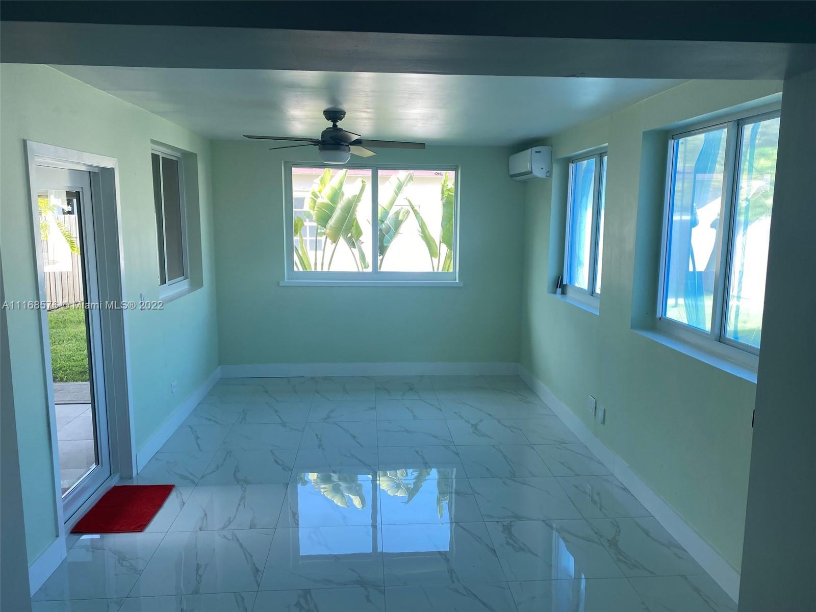 6561 Southwest 30th Street, Unit FRONT Miami, FL 33155 - Photo 8 of 18 an empty room with wooden floor and windows