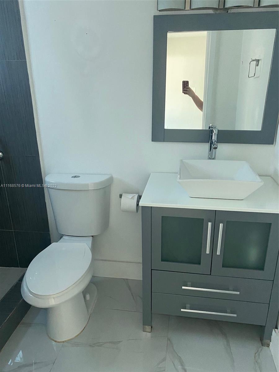 6561 Southwest 30th Street, Unit FRONT Miami, FL 33155 - Photo 9 of 18 a bathroom with a toilet and a sink