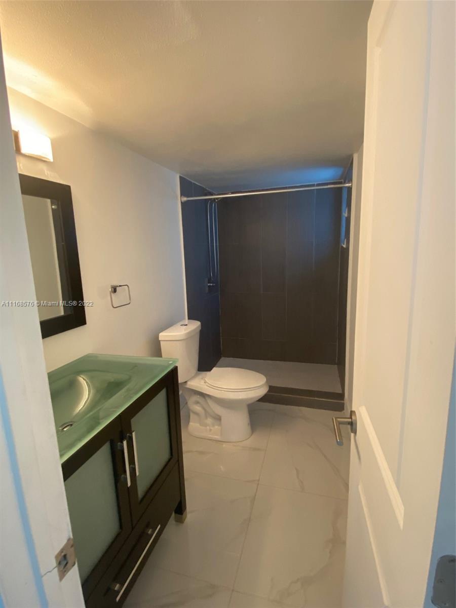 6561 Southwest 30th Street, Unit FRONT Miami, FL 33155 - Photo 10 of 18 a bathroom with a toilet and a shower