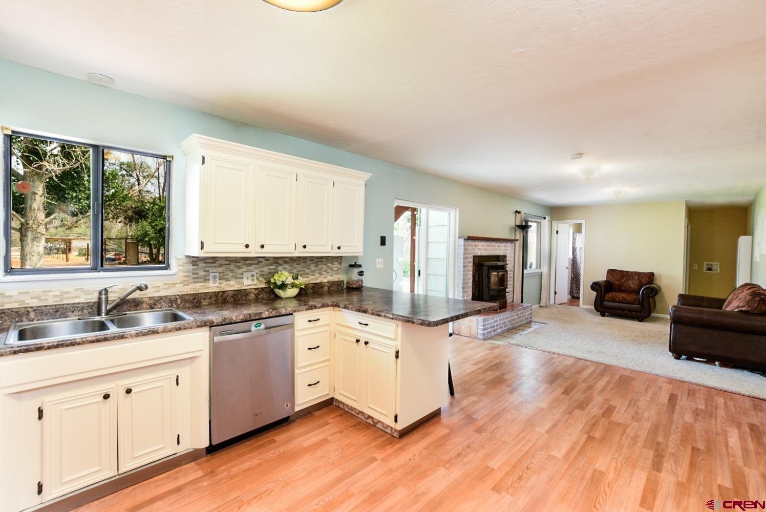 22247 H75 Road Delta, CO 81416 - Photo 15 of 35 a kitchen with a sink stove and wooden cabinets