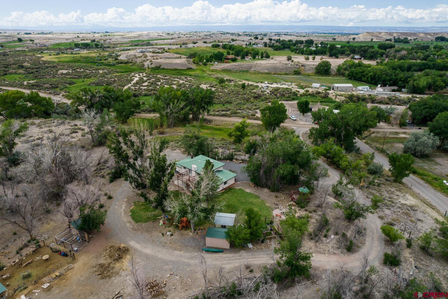 22247 H75 Road Delta, CO 81416 - Photo 29 of 35 an aerial view of green landscape with trees houses and mountain view