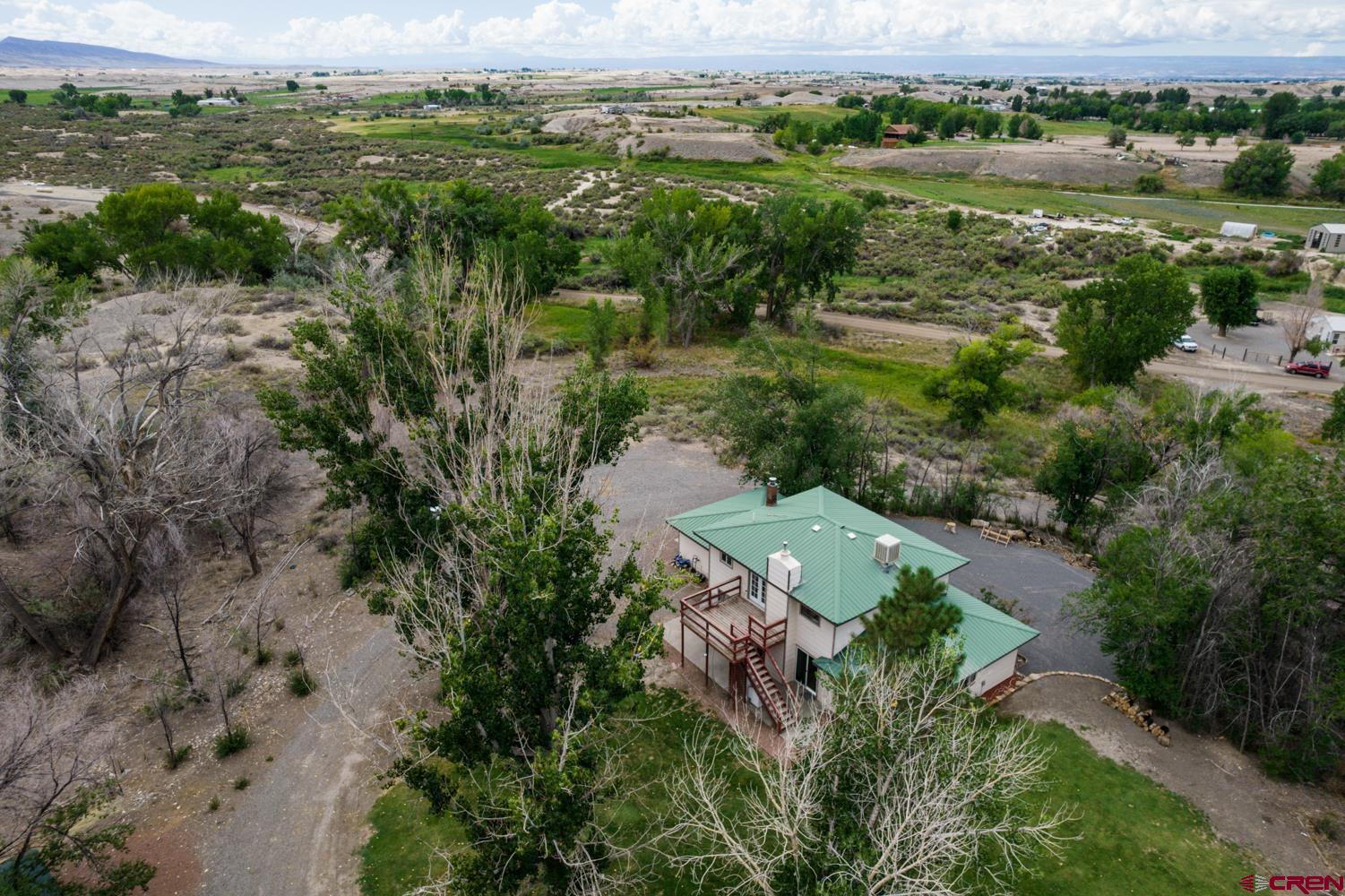 22247 H75 Road Delta, CO 81416 - Photo 35 of 35 an aerial view of green landscape with trees houses and lake view