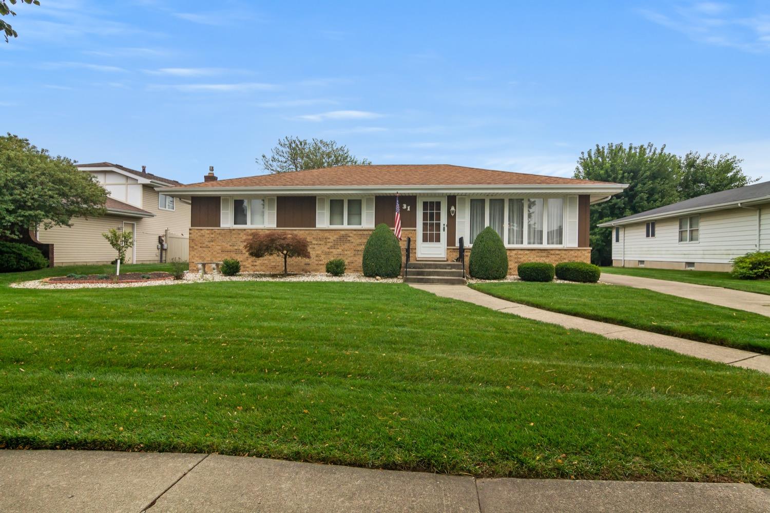 a front view of a house with a yard table and chairs