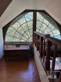 a living room with wooden floor and windows