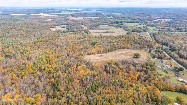 an aerial view of residential houses with outdoor space and trees