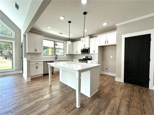 a kitchen with a refrigerator cabinets and wooden floor