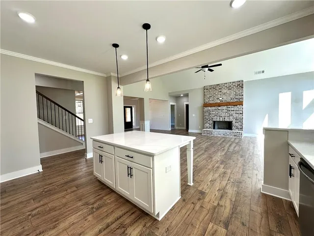 a kitchen with stainless steel appliances granite countertop a sink a stove and a wooden floors