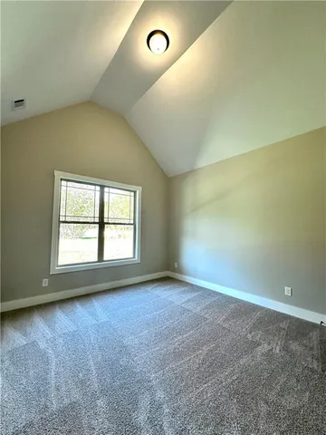 a view of an empty room with closet and wooden floor