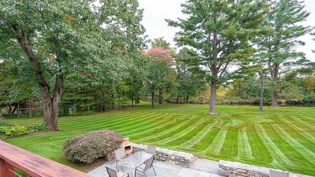 84 Wildwood Drive Needham, MA 02492 - Photo 12 of 36 a view of a backyard with large trees
