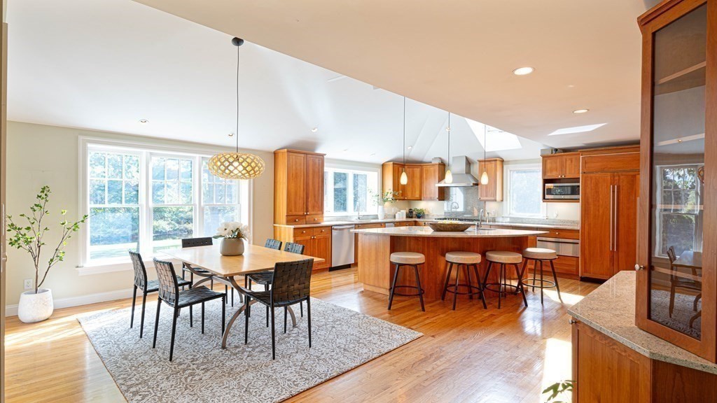 84 Wildwood Drive Needham, MA 02492 - Photo 4 of 36 a dining hall with stainless steel appliances granite countertop a stove a refrigerator a dining table and chairs with wooden floor