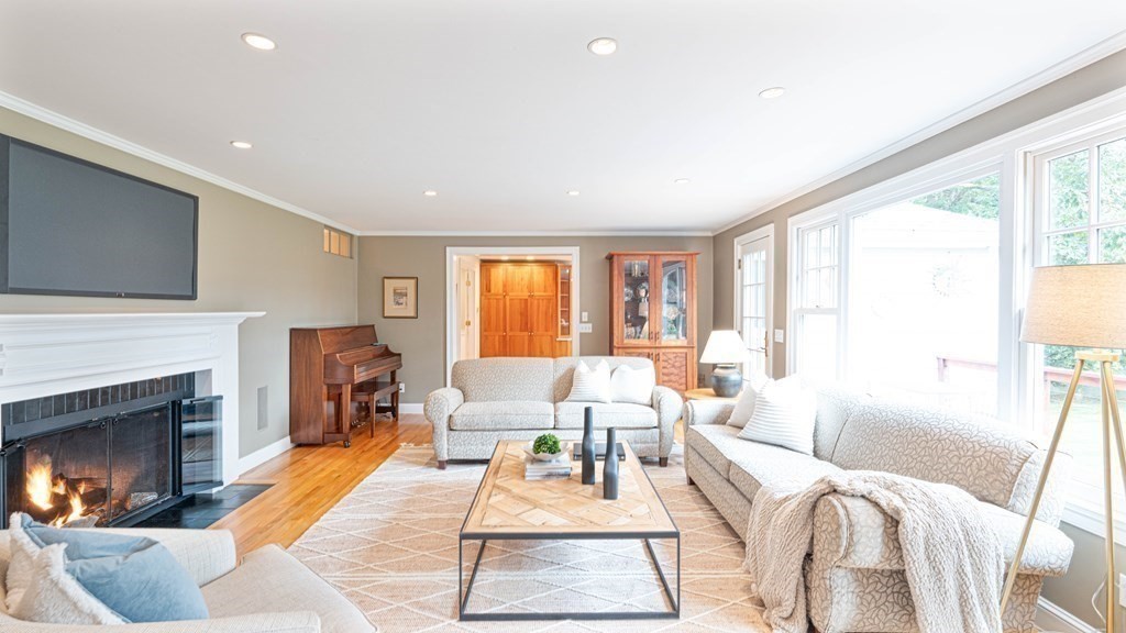 84 Wildwood Drive Needham, MA 02492 - Photo 10 of 36 a living room with furniture a fireplace and a large window