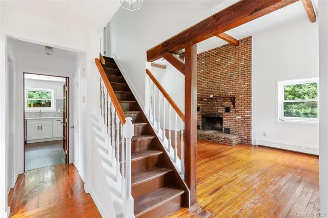 a view of a hallway with wooden floor and staircase