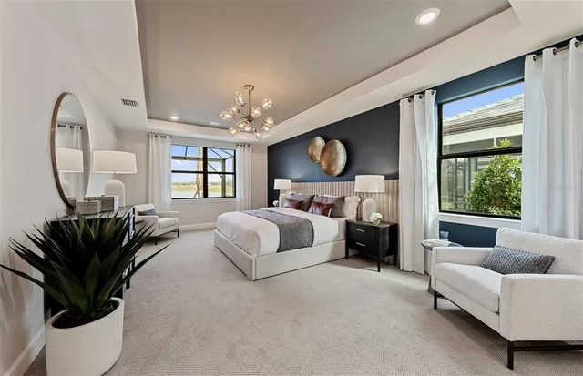 a spacious bedroom with a bed couch tv and window