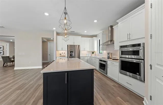 a kitchen with a sink stainless steel appliances and white cabinets