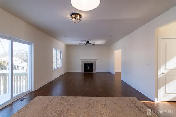a view of a room with wooden floor and kitchen view