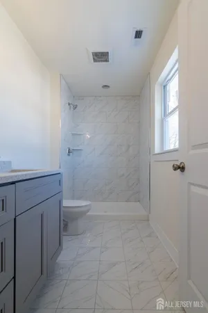 a bathroom with a toilet and a shower