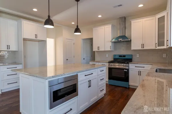 a kitchen with stainless steel appliances granite countertop a stove a sink and a refrigerator