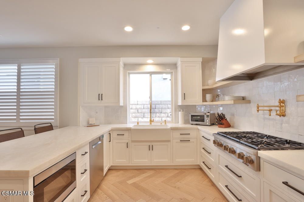 4630 Rio Bravo Court Moorpark, CA 93021 - Photo 24 of 58 a large white kitchen with a stove a sink a refrigerator and cabinets