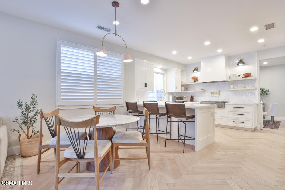 4630 Rio Bravo Court Moorpark, CA 93021 - Photo 31 of 58 a kitchen with stainless steel appliances kitchen island granite countertop a dining table chairs and white cabinets