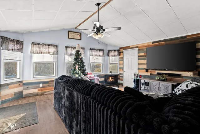a living room with furniture a large window and flat screen tv