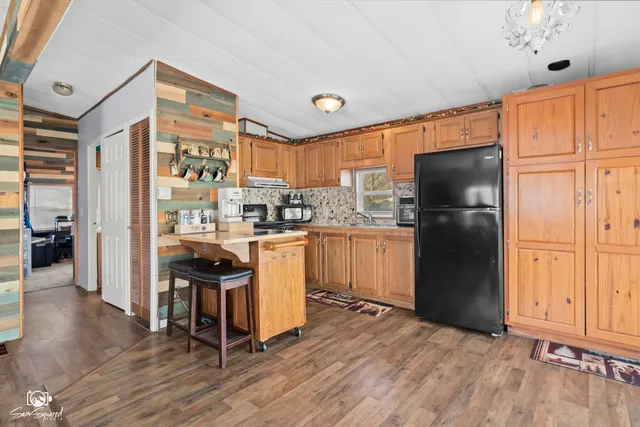 a kitchen with a refrigerator a stove and wooden cabinets