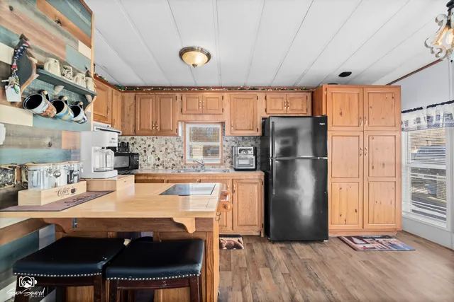 a kitchen with stainless steel appliances granite countertop a refrigerator a sink a stove and island