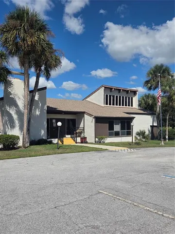 a view of a house with a yard and large trees