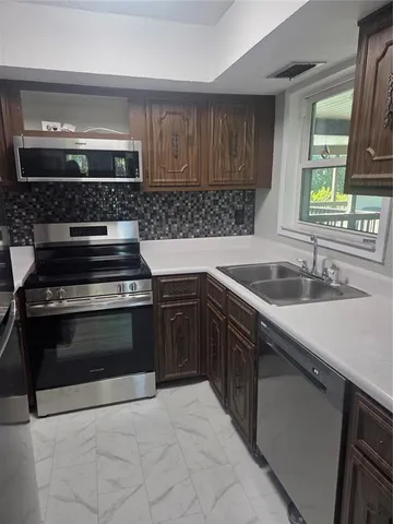 a kitchen with a sink stove and microwave